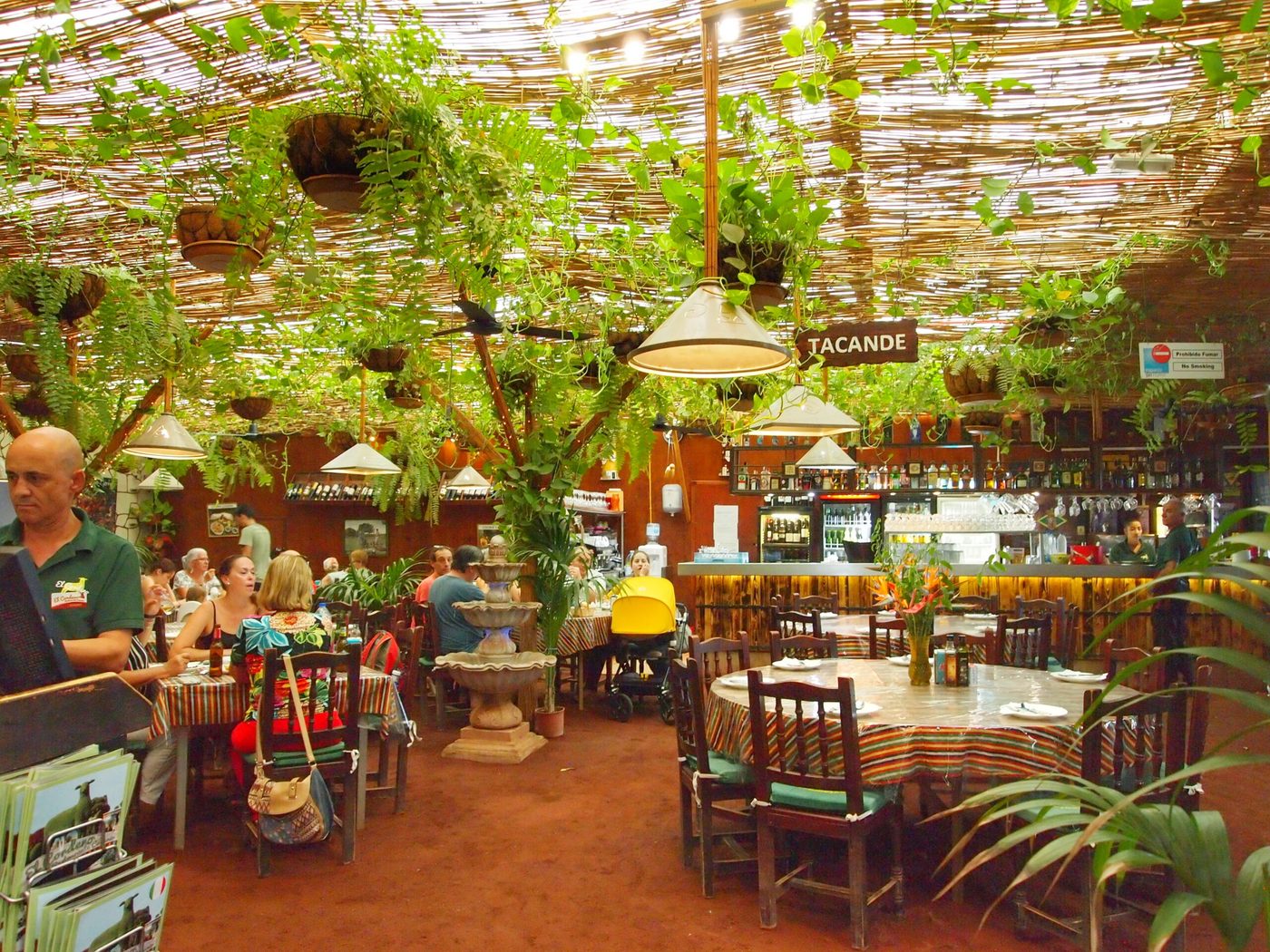 Rincón del restaurante con mobiliario rústico de madera entre plantas